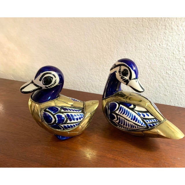 Vintage pair of duck figurines from the Tonal region of Mexico. Hand painted ceramic in a bright cobalt blue with brass...