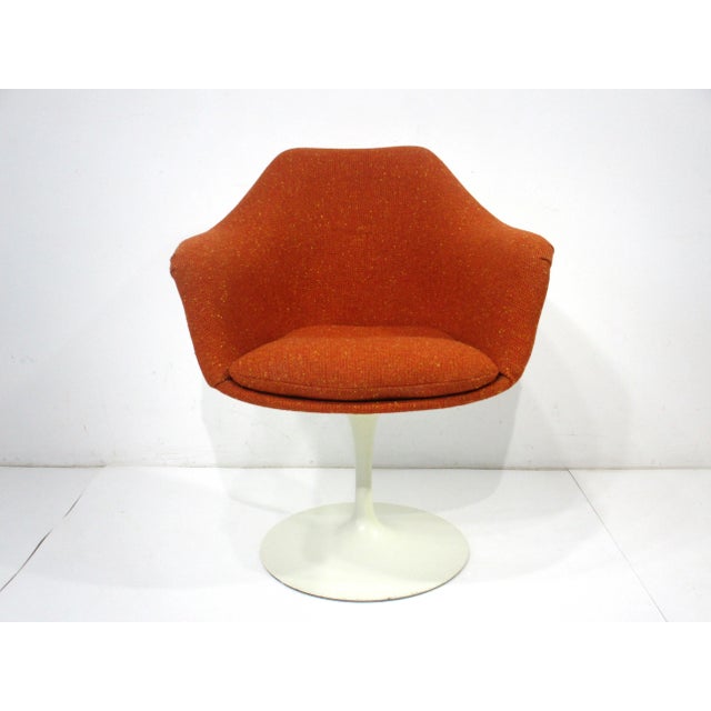 A special order upholstered non swiveling tulip arm chair with white back and base designed by Eero Saarinen . This...