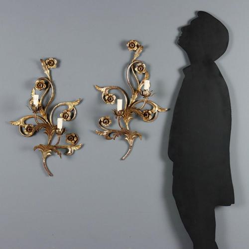 Pair of iron and sheet metal wall sconces featuring leaves and flowers, gilded with Mecca. Two lights supported by curved...