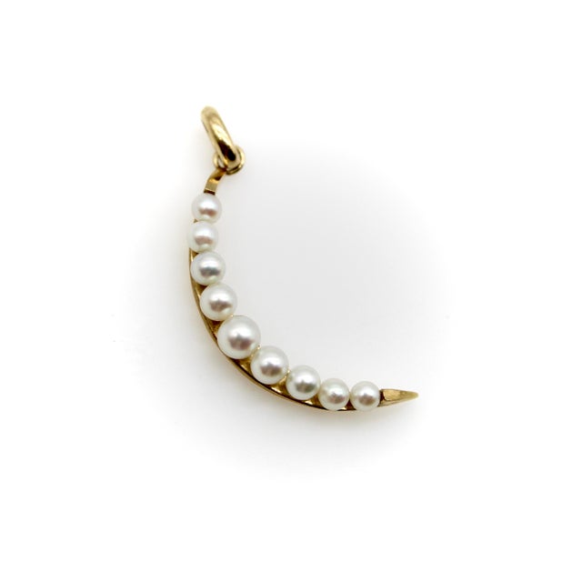 This Mid-Century Modern crescent moon pendant has a sleek design with graduated pearls that look like milky dew drops. The...