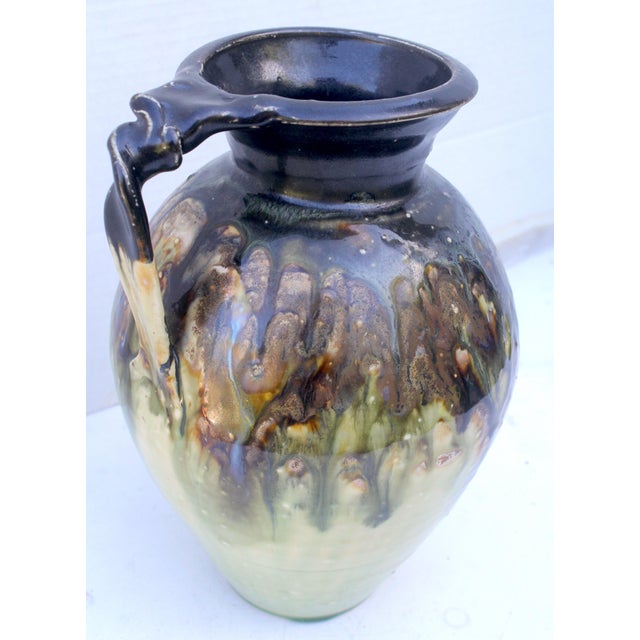 This versatile 9.5-inch hand-thrown ceramic studio pottery pitcher was created in 2012 by the contemporary Southern...