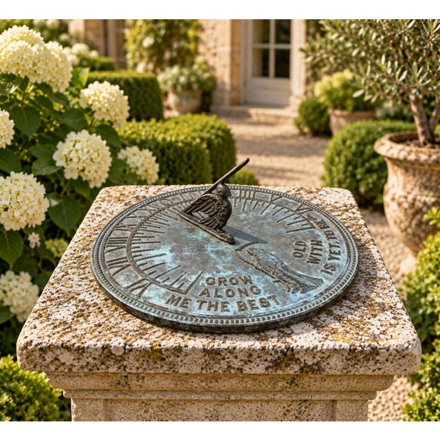 A classic vintage iron garden sundial inspired by traditional English estate landscapes, reading "Grow old along with me....