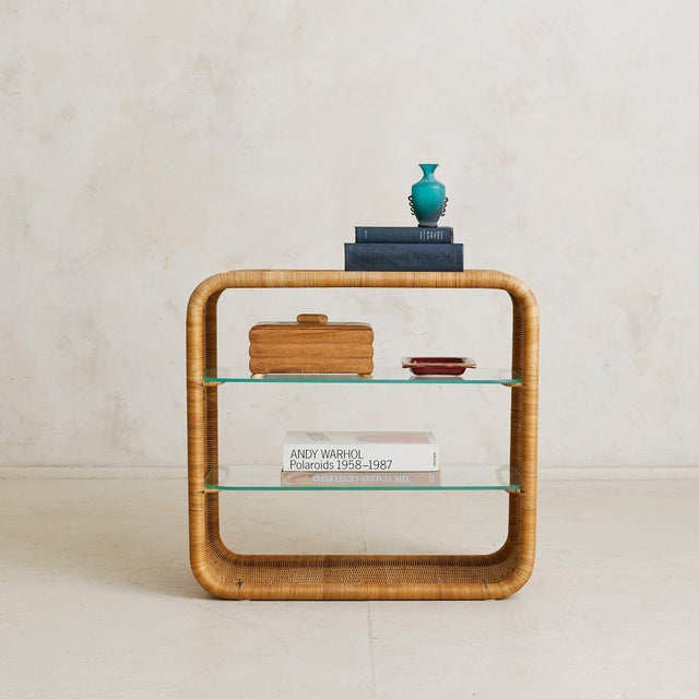 A French rattan shelf, dating to the 1960s and crafted in the manner of architect Louis Sognot. The rectangular frame is...