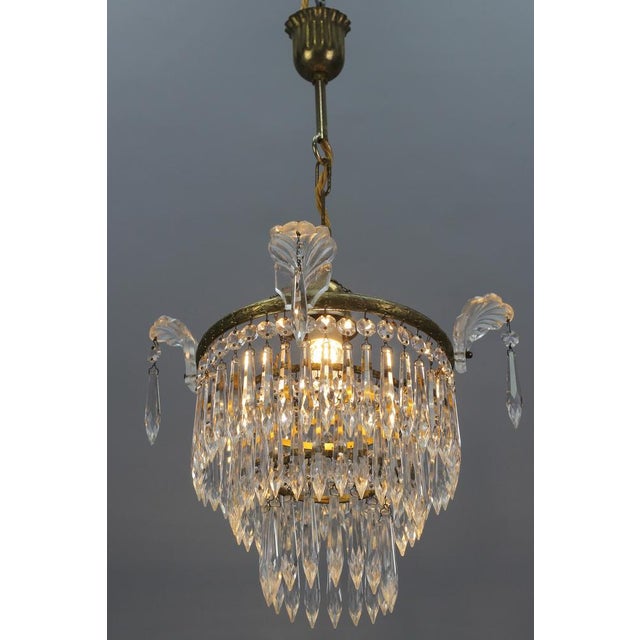 French Empire style crystal glass and brass three-tired chandelier, the 1930s. Charming and compact French Empire-style...