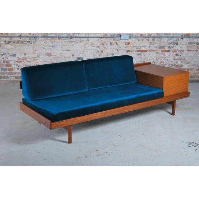 Mid Century teak daybed with teal colour velvet cushions, circa 1960s. The side table with magazine compartment flips up...