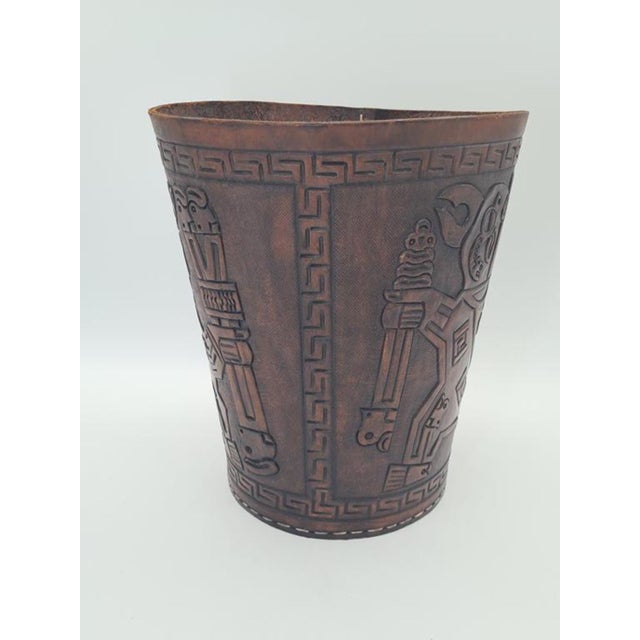 A decorative vintage basket/container made of embossed leather featuring a distinctive motif inspired by pre-columbian and...