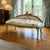 Elegant vintage French Rococo style settee featuring luxurious white damask upholstery beautifully paired with an ornate...