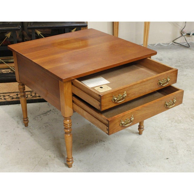 This piece features a warm, polished wood finish that highlights its natural grain and traditional character. Two front...