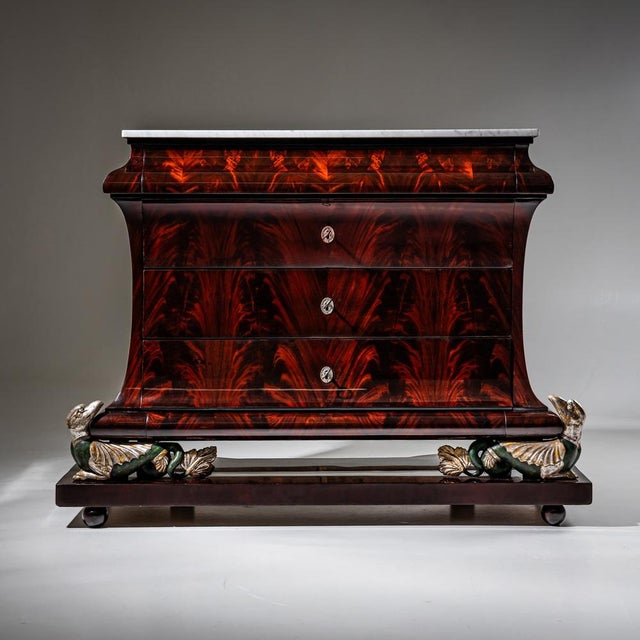 Large Empire mahogany-veneered chest of drawers raised on an exceptionally crafted base supported by chimera figures with...