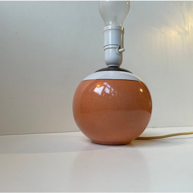 Circular table light in glazed ceramic and bronze. 3 colors high-lighted by a small stripe in gold-glaze. It features its...