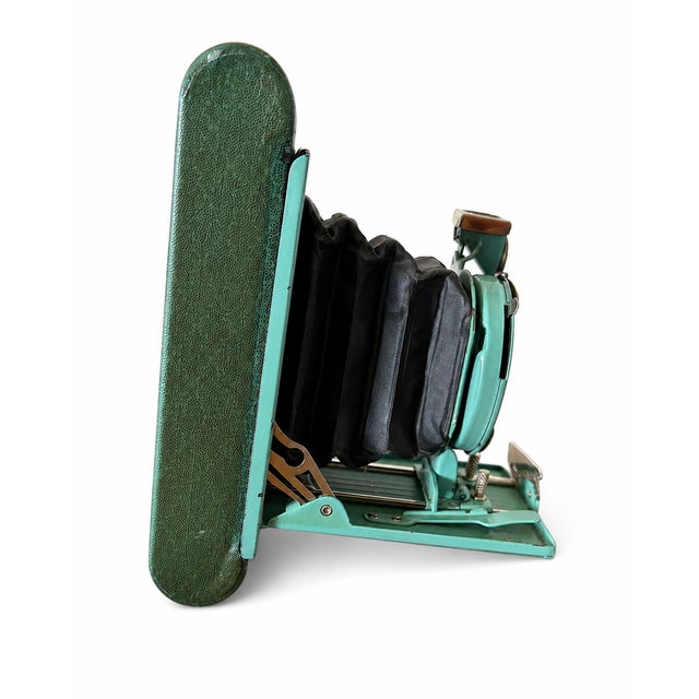 Charming antique Kodak Petite folding camera dating to the early 1930s, featuring its distinctive turquoise-green enameled...