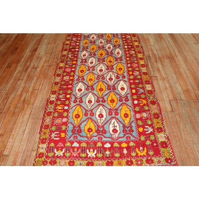 Antique Turkish milas runner featuring a Caribbean blue ground, accents in bright red and saffron, Measures: 3'7" x 13'6".