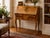This charming French slant-front secretary immediately captivates with its balanced proportions, the gentle curves of its...