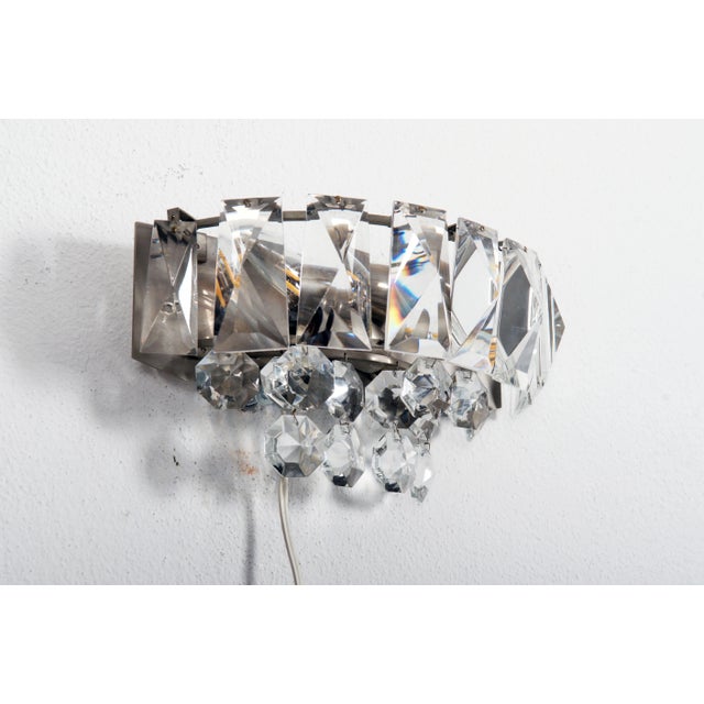 Brass frame nickel-plated fitted with two E14 sockets up to 60Watts. Covered with faceted crystal prisms. Manufactures in...