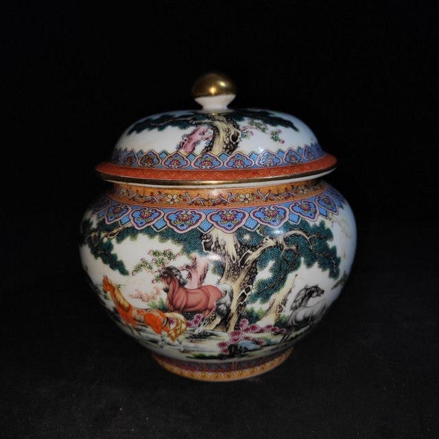A beautiful pair of Chinese Famille Rose porcelain covered jars. The white ground is finely hand-painted with the classic...