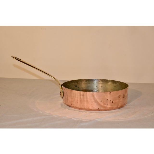 Circa 1950's French copper sautée pan. This sauté pan is stamped made in France and has an applied brass handle, attached...