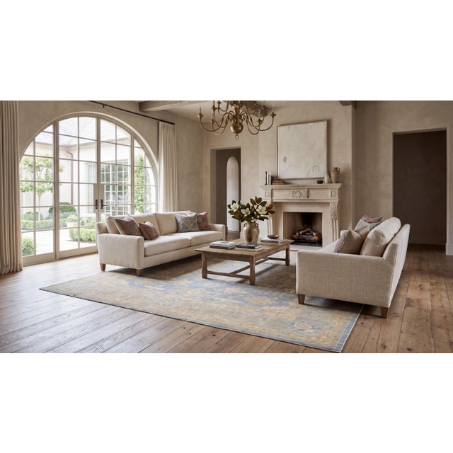 Elevate your space with this modern hand-knotted Oushak-style wool area rug, crafted in a serene soft blue, beige, and...