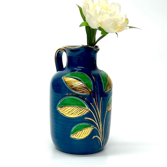 Blue, green, and gold pitcher. This is a stunning blue, green, and gold ceramic pitcher with a leaf motif design by Aldo...