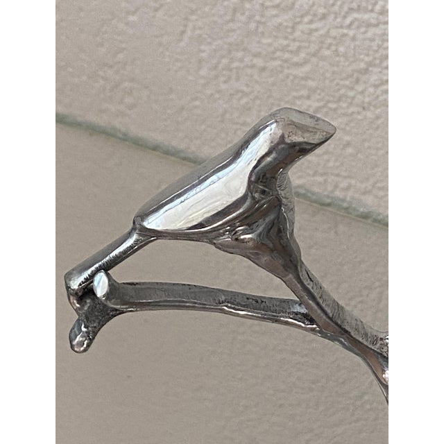 Charming polished aluminum serving tray depicting two bowls joined around a tree on which a bird perches. A rare and...