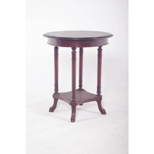 Round coffee table. with a smooth top, resting on four elegant turned legs connected to each other by a bottom rail in a...