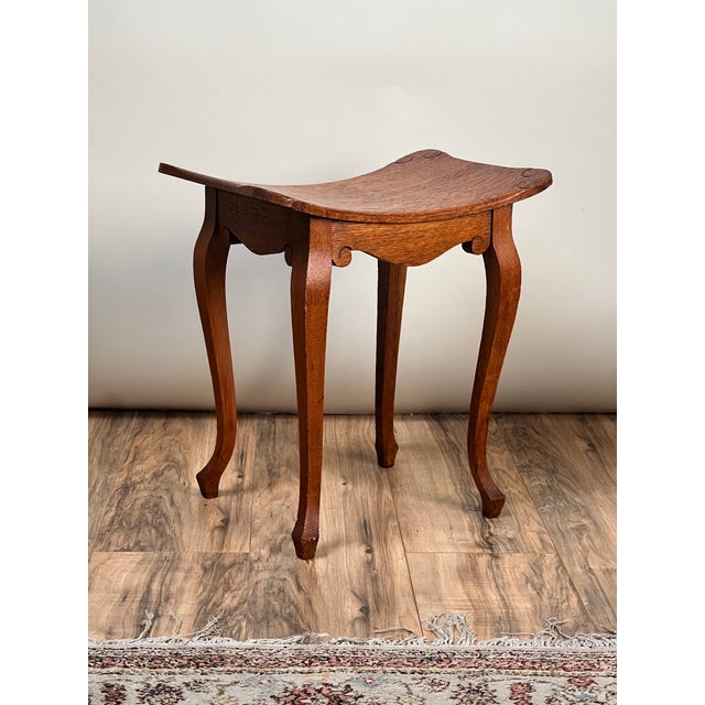 With its graceful saddle-shaped seat and honest craftsmanship, this antique Arts & Crafts footstool embodies the...