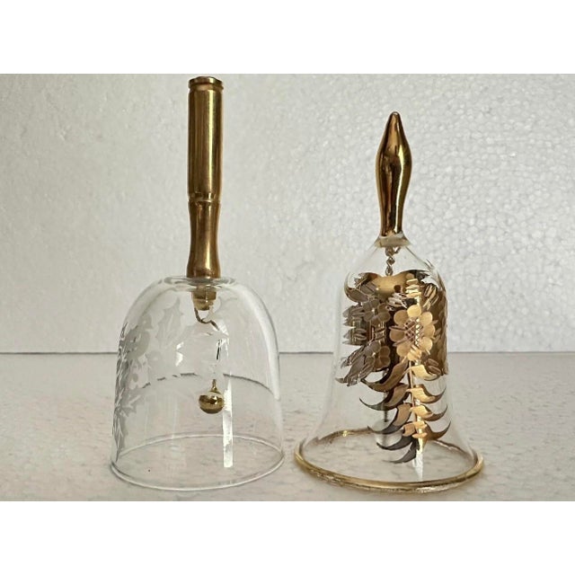 Set of 2 beautiful gold plated bells with gold plated handles. One is a bird motif and the other is a gold floral motif....