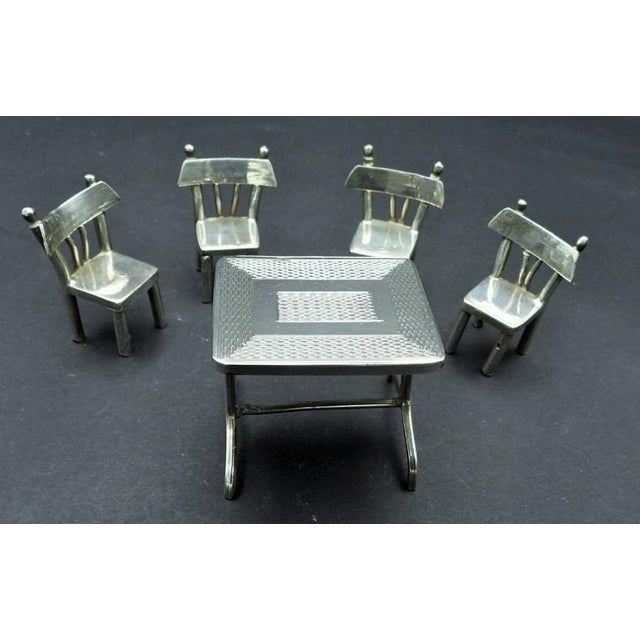 This marvelous antique miniature table and set of 4 chairs is created in 900 coin silver and was most likely Made in...