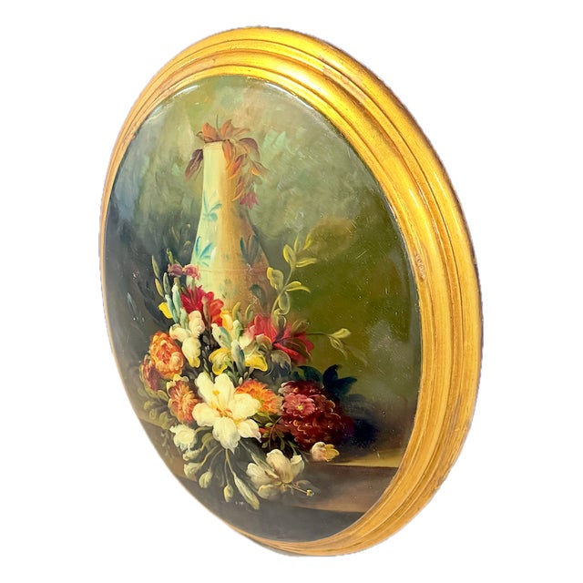 Vintage oval concave floral still life oil painting with gilt attached frame. Depicts a still life of flowers and vase....