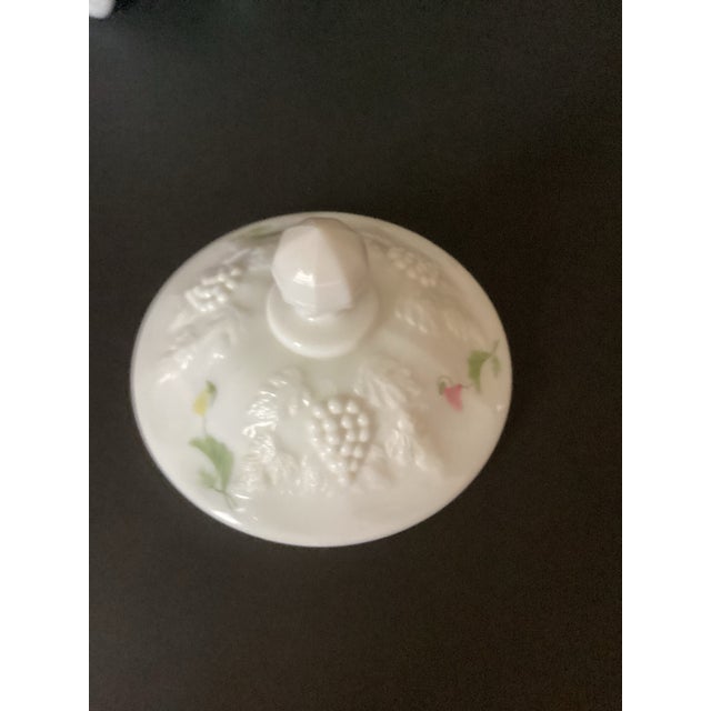 Milk glass covered jar by Westmoreland Glass Co. Pressed glass with a painted or pressedfloral motif with a grape leaf...