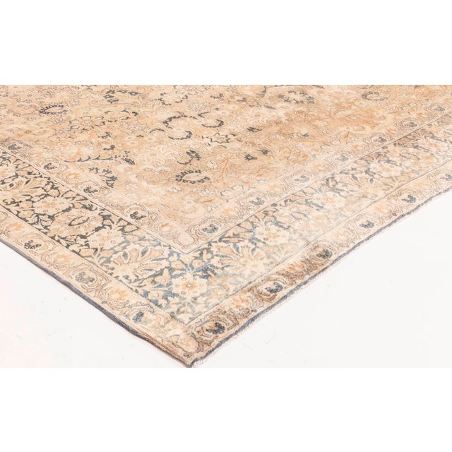 An early 20th century Persian Kirman (Kerman) antique carpet, the camel field with a whimsical allover design of cream,...