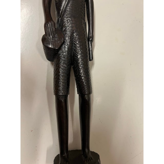 African wood carving out of ironwood. Statue of a tribal man. Stands 14” tall.