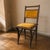 A distinctive Art Nouveau dining chair with carved solid wood detailing, mustard-yellow velvet upholstery, and brass...