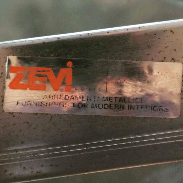 Striking dining table produced by Zevi in Italy during the 1970s. The piece features a rectangular chromed metal and brass...