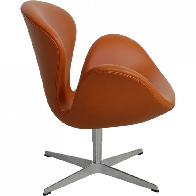 Arne Jacobsen Swan chair upholstered in walnut colored classic semi anilin leather. The chair is from around 2000-2010 and...