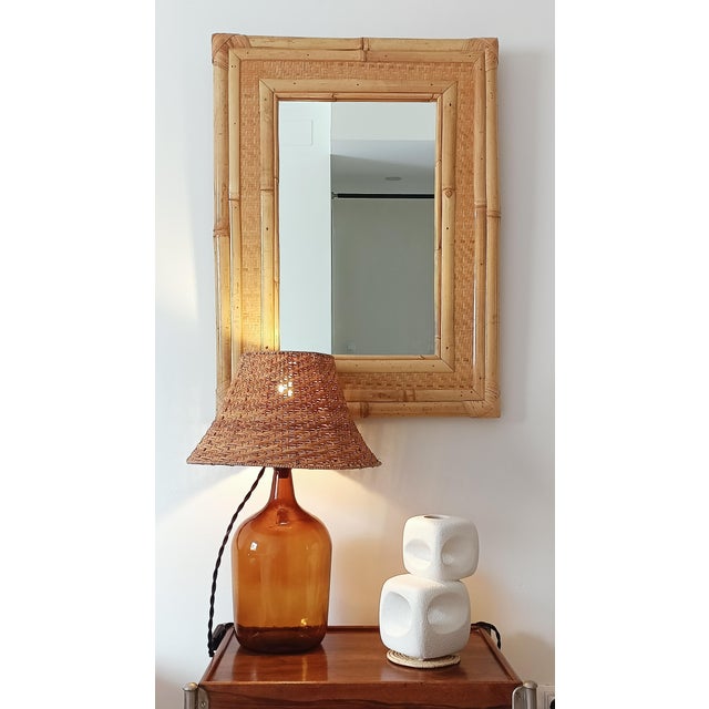 Large Mid-Century Modern mirror featuring a frame crafted from bamboo, cane, and woven rattan. Handmade in Spain circa the...
