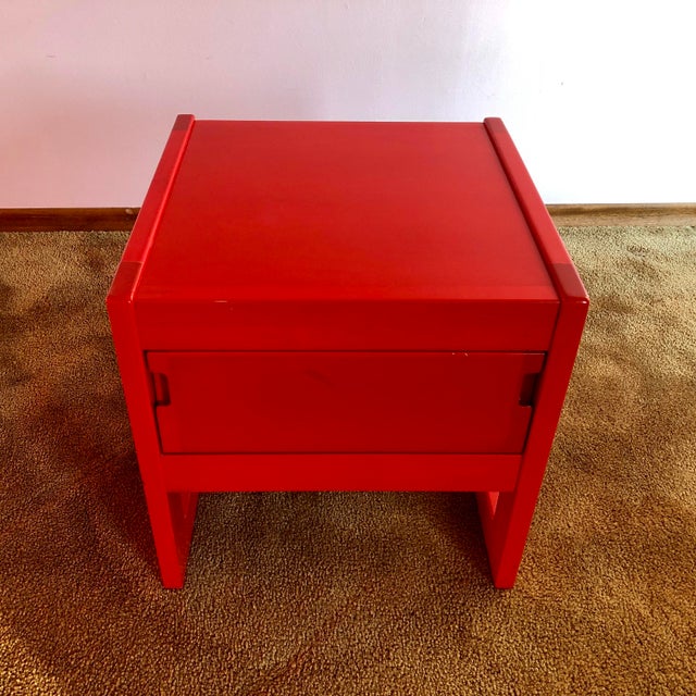 Exceptionally rare modern night table in bright red that perfectly embodies the warm colours, soft lines, and...