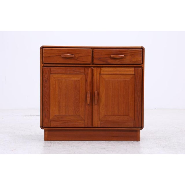 Vintage chest of drawers from Uldum Møbelfabrik with a striking teak grain and intricately crafted fronts. Two drawers and...