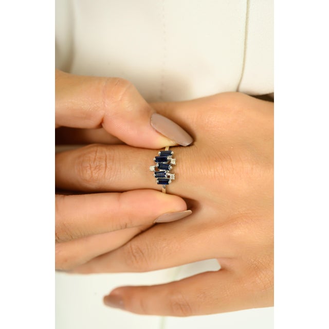 Bold and contemporary, this exquisite ring showcases a striking arrangement of baguette-cut sapphires totaling 0.75...