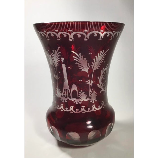 This Bohemian Crystal Vase is ornately decorated with stags, flora, villas and a decorative diamond pattern. The dark ruby...