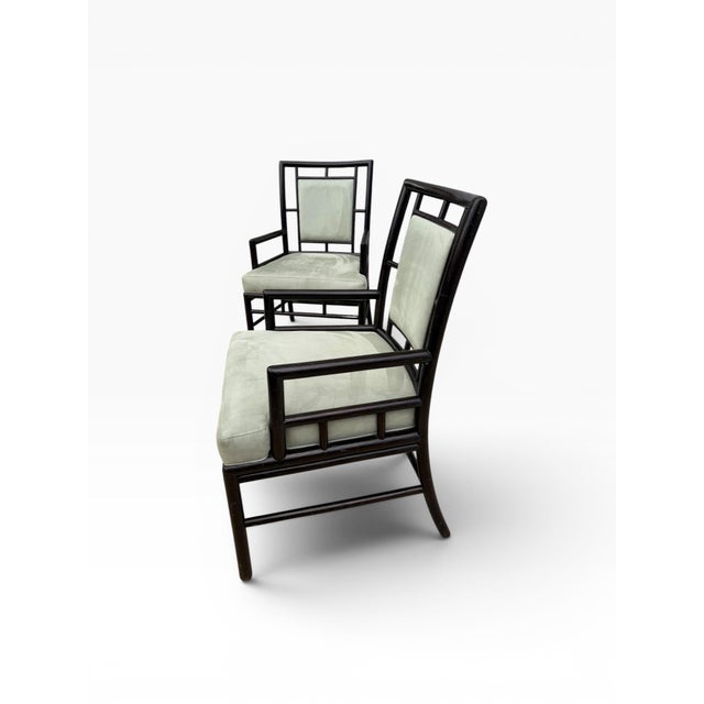 A striking pair of vintage McGuire San Francisco lounge chairs featuring dark faux-bamboo frames with an open geometric...