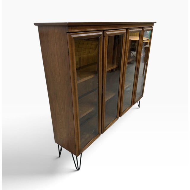 This Mid-Century Modern 4-Door Walnut Display Cabinet with Hairpin Legs is a stunning piece of furniture that combines...