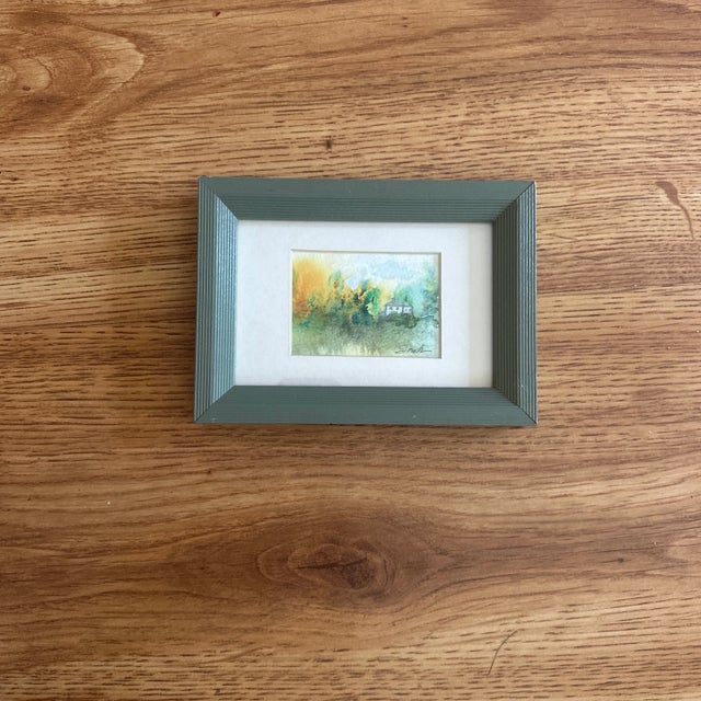 This serene landscape captures a tiny cottage nestled among golden foliage, enveloped in a soft, misty glow. The autumnal...