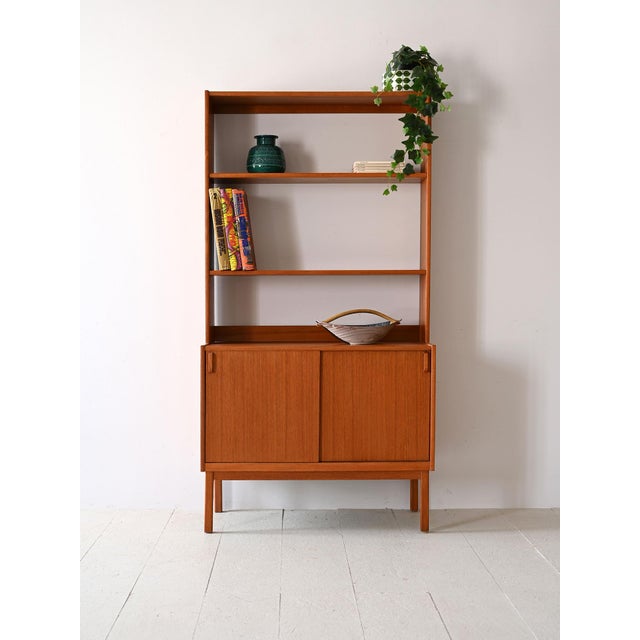 Vintage 1960s teak furniture, composed of open shelves and a lower compartment with sliding doors. A modern piece that...
