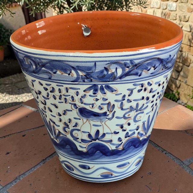 This hand-painted glazed terra-cotta wall planter with a blue bird motif is a charming decorative collectible made in...