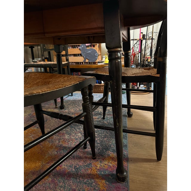 Charming vintage dining set featuring a solid wood round drop-leaf dining table paired with four classic Hitchcock-style...