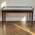 The classical discipline of the Louis XVI period gives this mid-century coffee table its refined character. Inspired by...