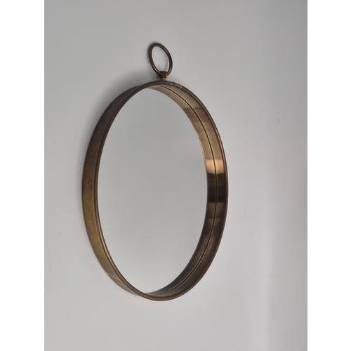 Pocketwatch shaped mirror with brass frame, by Firma Svensk Tenn, Sweden Modern 1950s. with beautiful patina which shows...