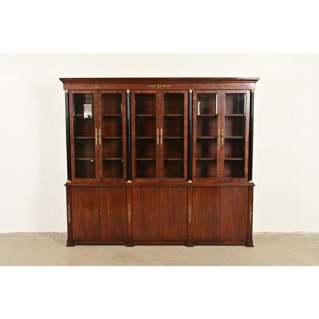 A beautiful monumental French Empire or French Regency Louis XVI style breakfront bookcase or dining cabinet In the manner...