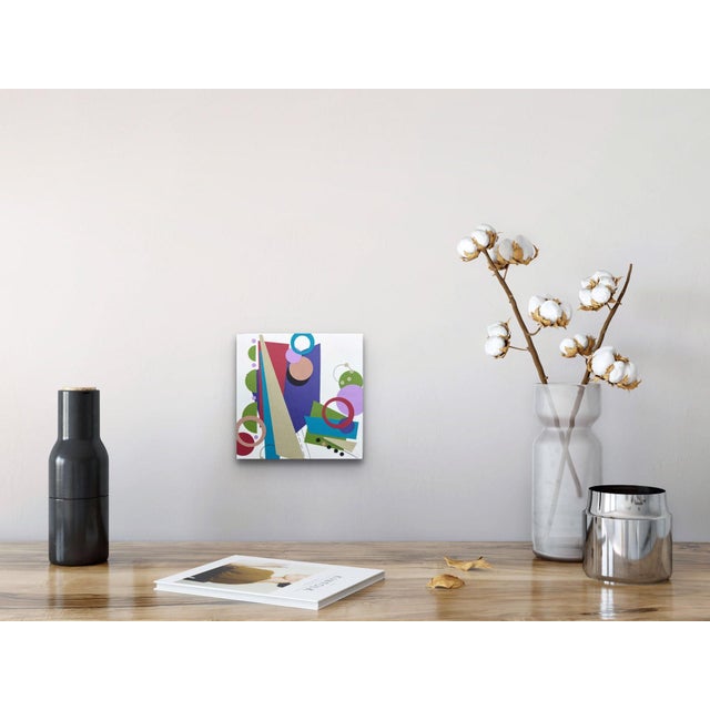 This paper collage features a dynamic interplay of geometric shapes and vibrant colors, creating an energetic composition...