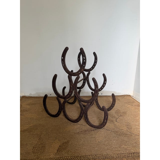 This listing is for an iron horseshoe wine rack. It has an allover patina and is a solid, heavy piece. 14.5" T x 14 5/8" W...